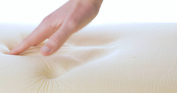 Touching and pressing a memory foam bed and pillow. Close up shoot.